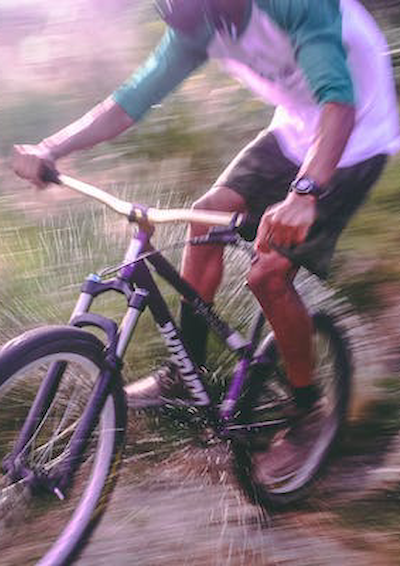 En dreng, der kører på mountainbike i skoven