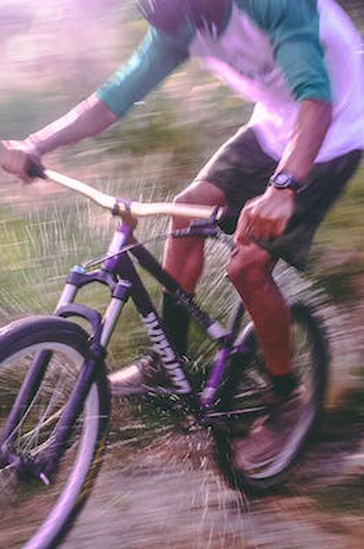 En dreng, der kører på mountainbike i skoven